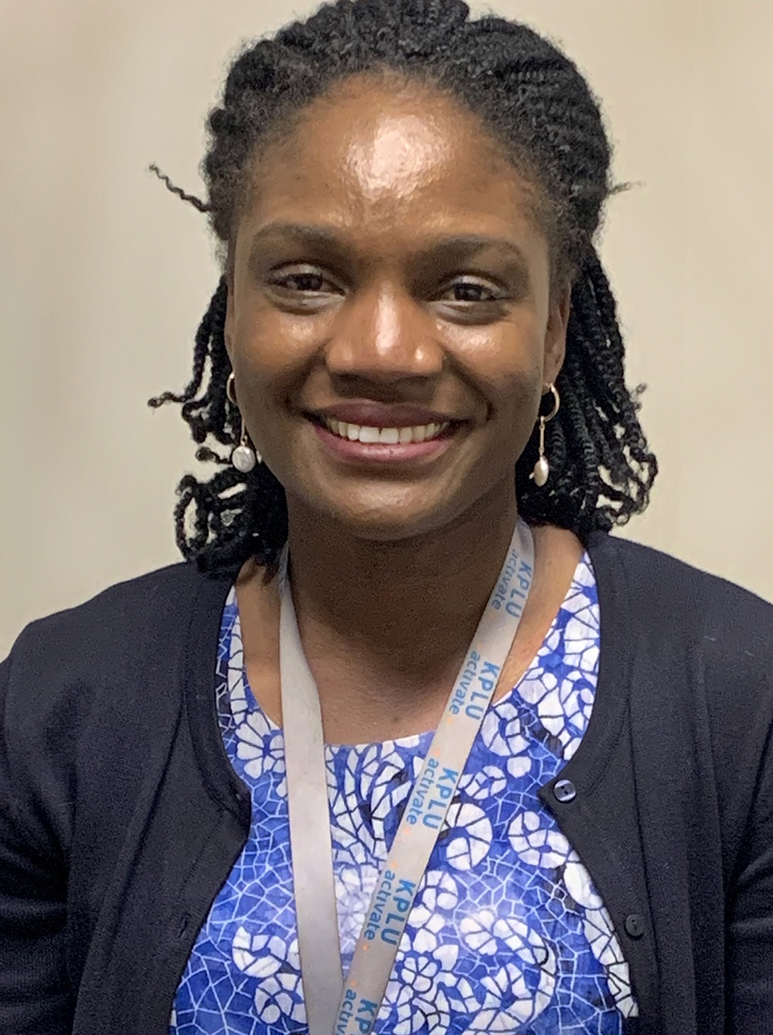 portrait of a health care worker smiling, wearing a blue top 