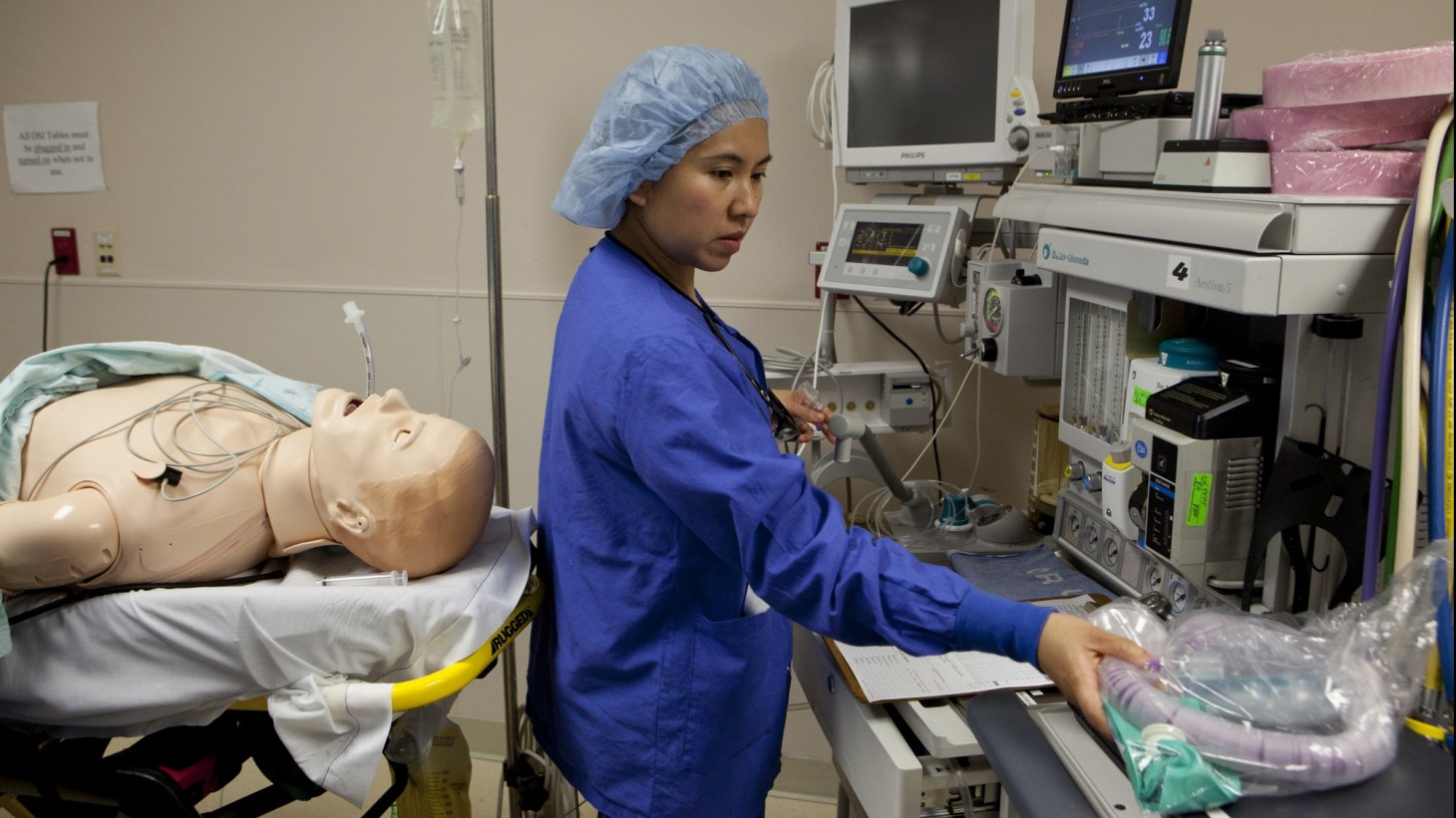 health care worker with patient mannequin for simulation