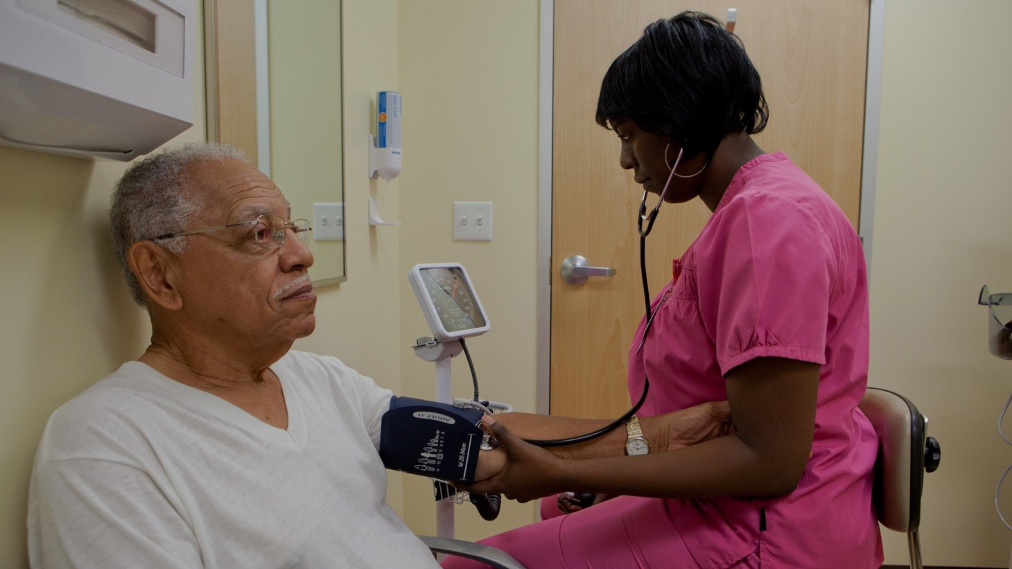 Nurse checking a elderly man's blood pressure 