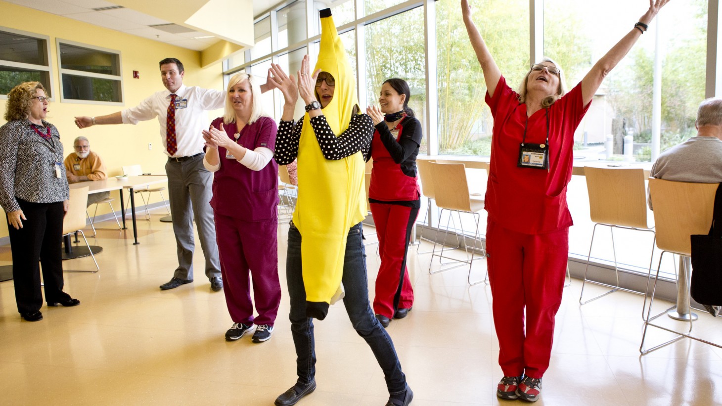 Health care workers (including one dressed a giant banana) exercising together