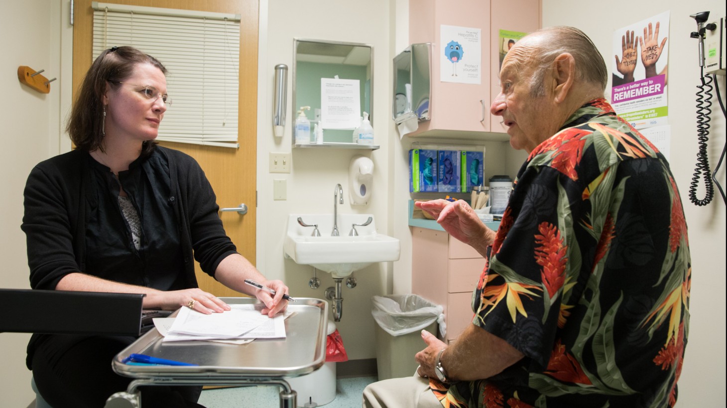 Female doctor with elderly male patient in an exam room