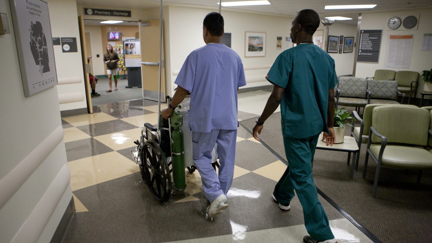 two transporters taking a patient in a wheelchair