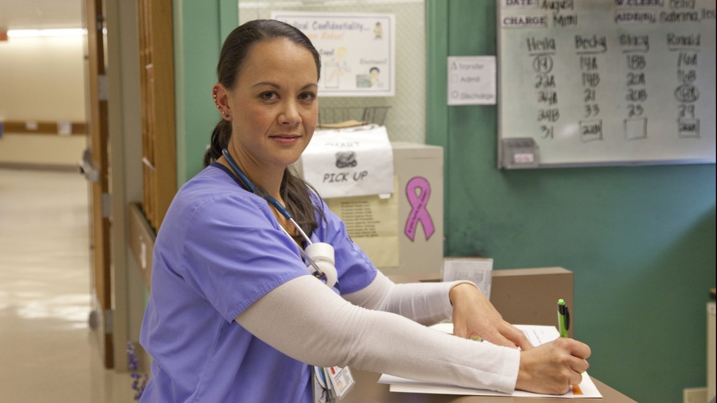 Nurse at a nurses' station writing down notes 